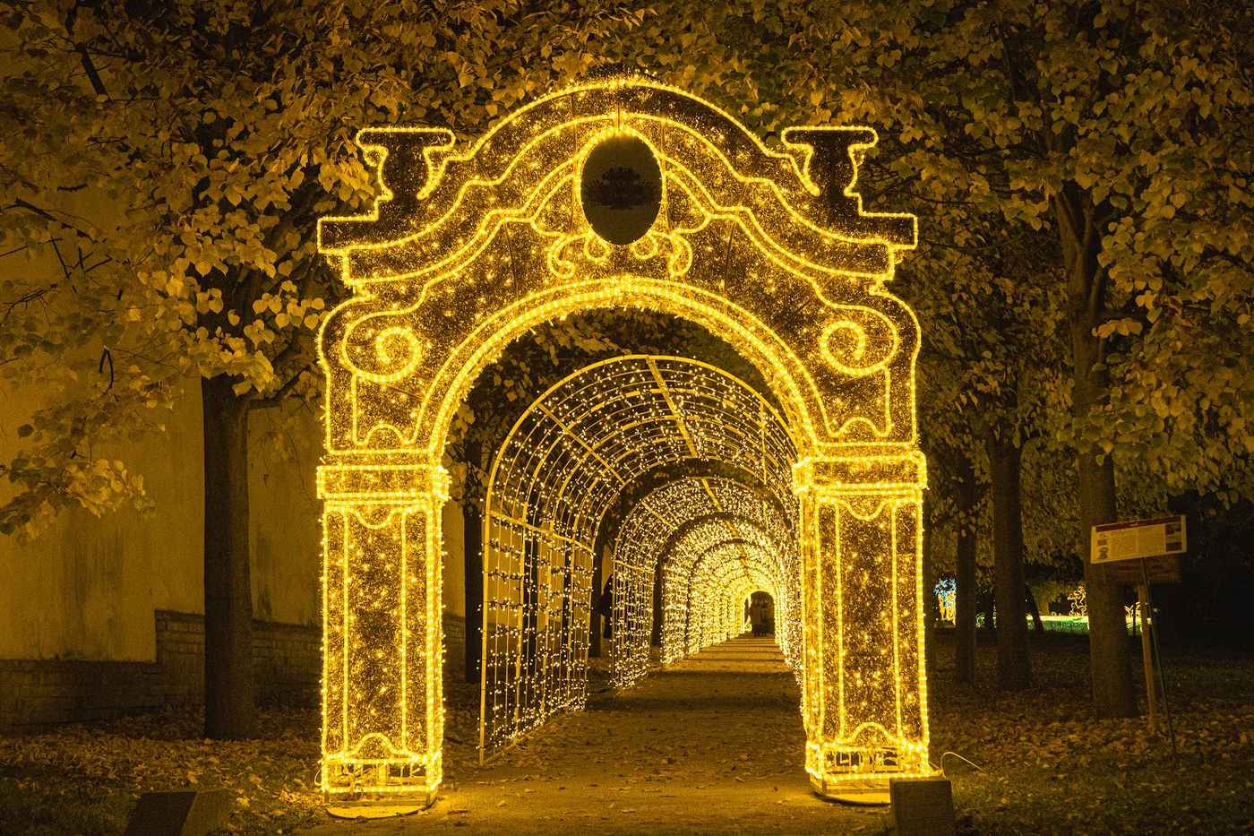 Ornate light gate leading into a long light tunnel in an alley